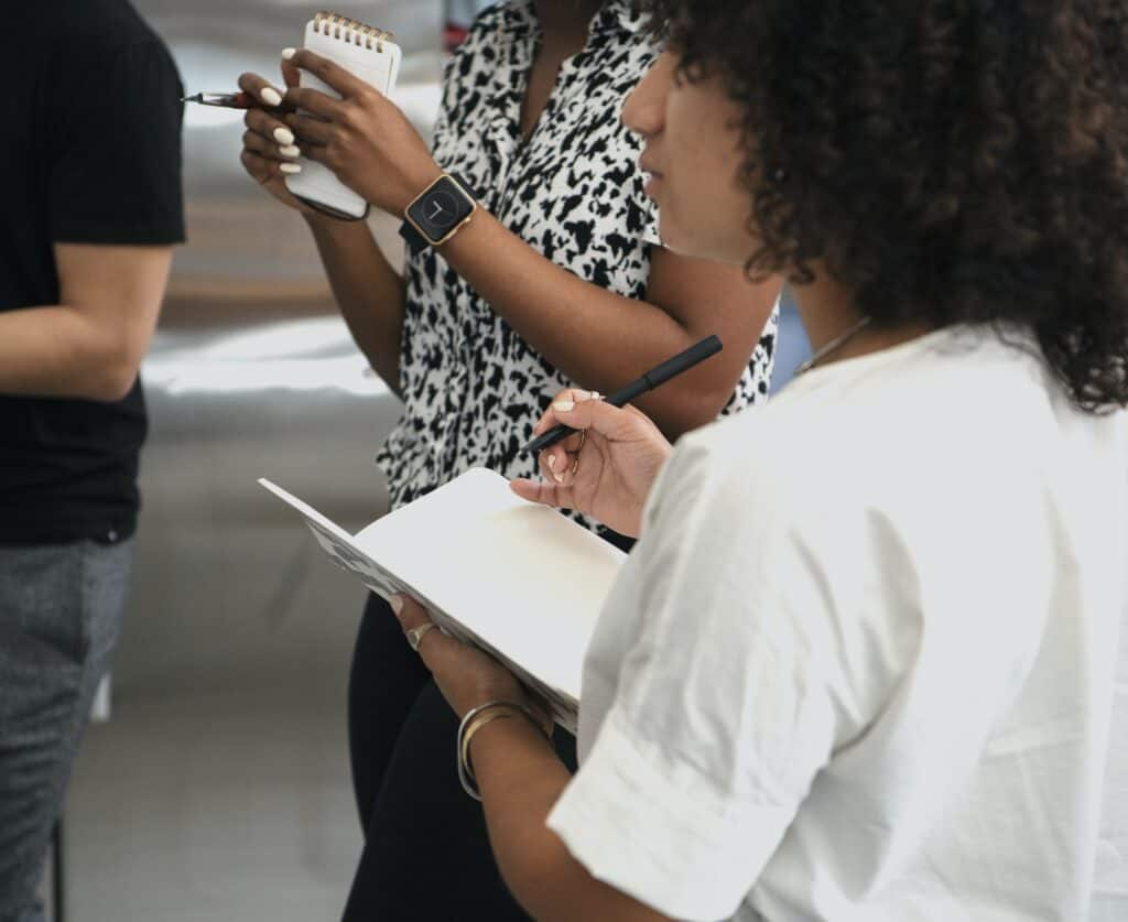 Black women taking down notes at a seminar