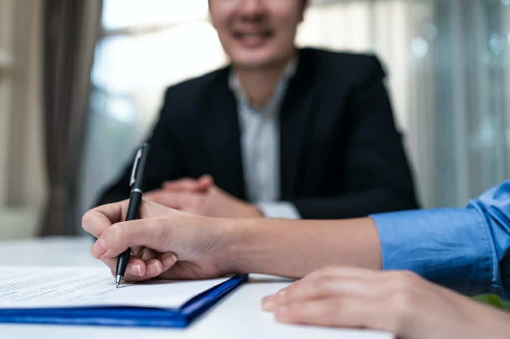 Close up hands of businesswoman sign contract agreement fter negotiation for Business deal.